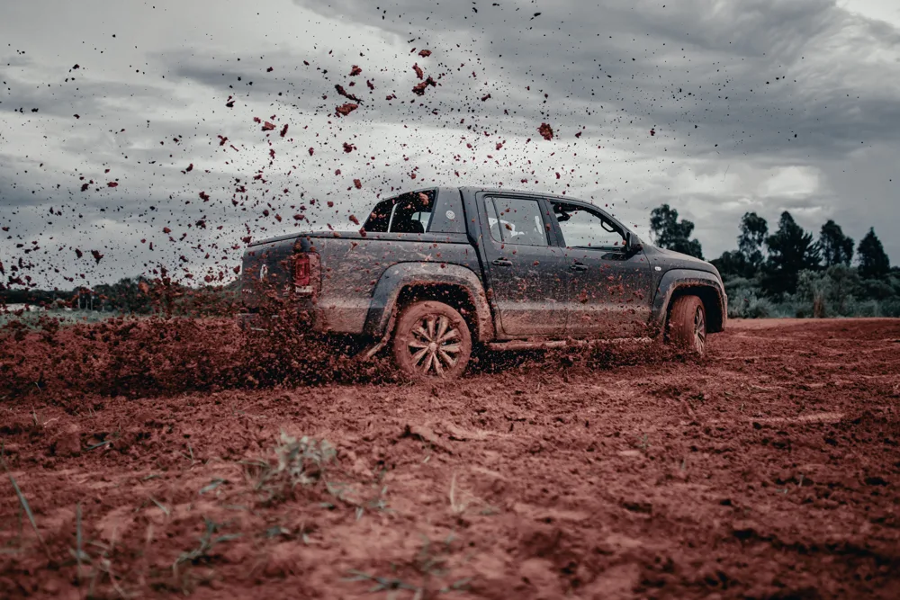 Picape 4x4 a diesel atravessando terreno com lama